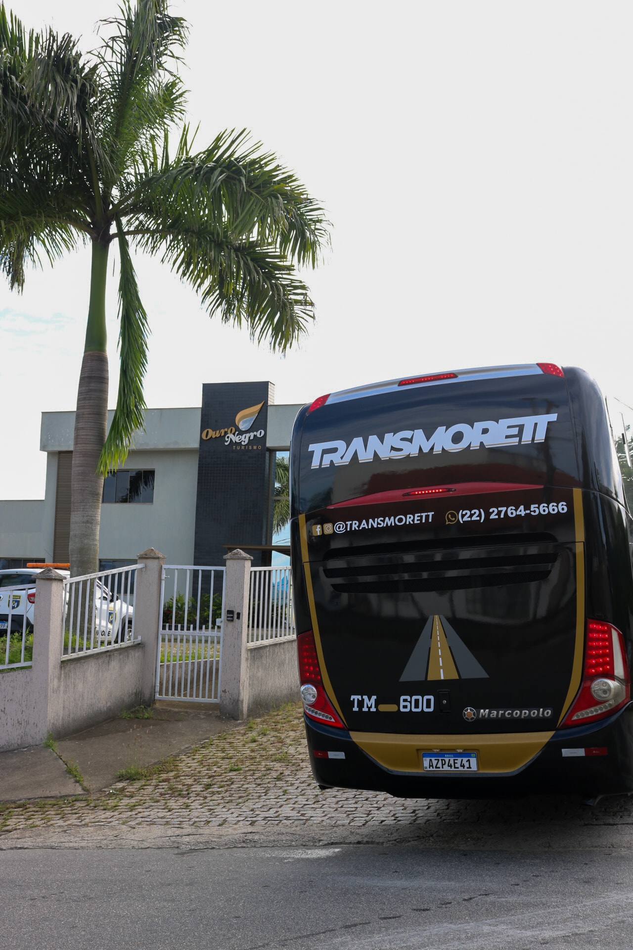 Ônibus executivo Transmorett em via pública, vista traseira
